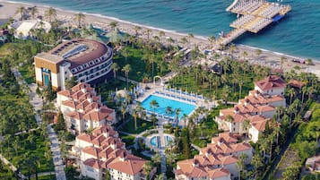 Ein Resort mit einem zentralen Pool, Zugang zum Strand und mehreren Gebäuden mit roten Ziegeldächern.