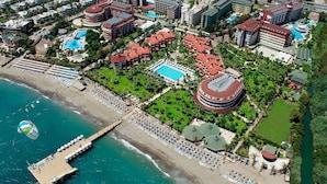 An aerial view of a resort with multiple buildings, a beach, and a pier. - Saphir Hotel & Villas - All inclusive (Alanya)