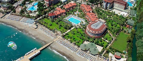 Vista aérea de um resort com vários edifícios, uma praia e um píer.