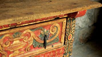A close-up of a wooden table with ornate carvings and a brass handle.