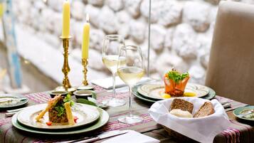 A dining table set with plates, glasses, and candles, suggesting a formal dining experience.