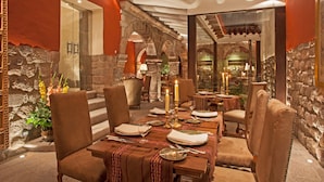 Un comedor con paredes de piedra, techo alto y ambiente acogedor.