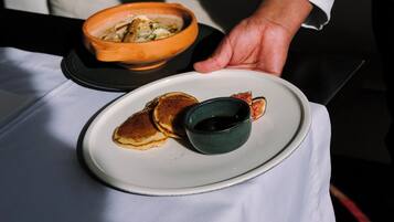 Een eettafel met een bord eten, een kom en een kopje.