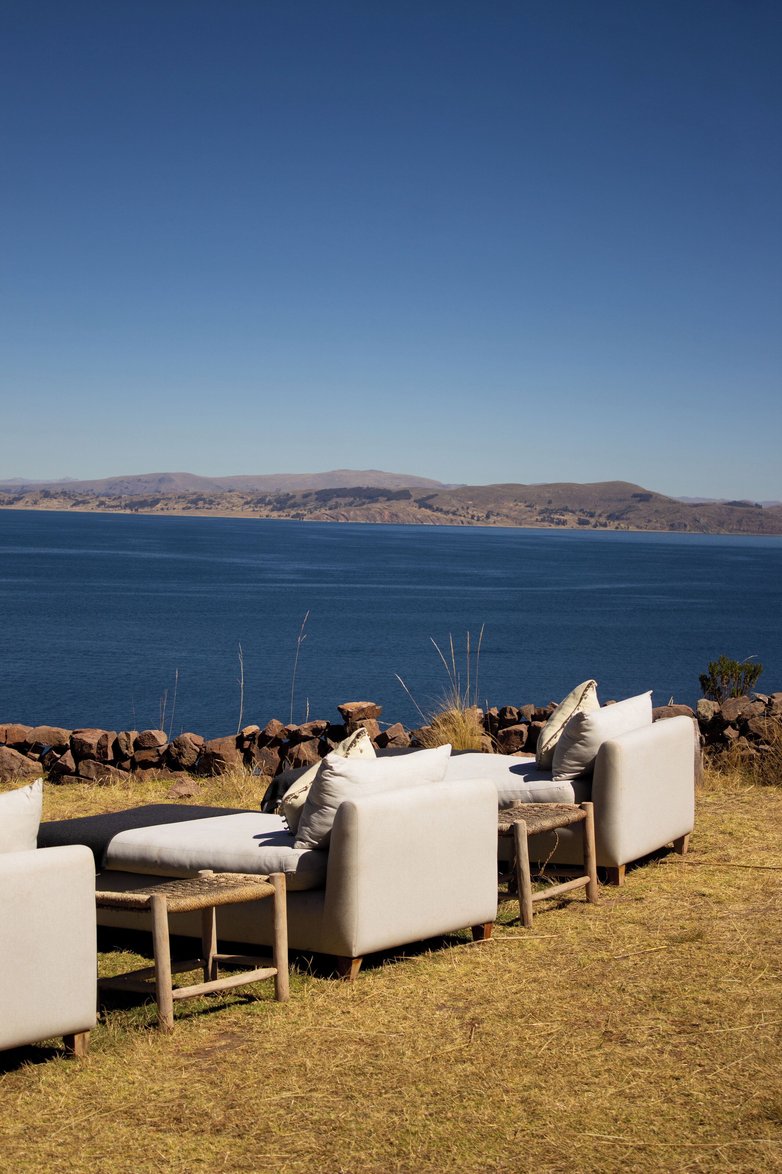 A seating area with a view of a large body of water and distant hills.