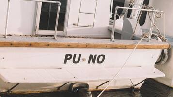 Um barco atracado em um cais, com cabine e área de convés visíveis.