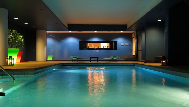An indoor swimming pool with a view of a bar area and seating. - Best Western Plus Hotel Le Favaglie (Cornaredo)
