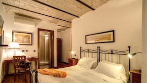 A bedroom with a bed, a desk, a chair, a nightstand, and a lamp. - Residenza Domizia- Guest House (Rome)