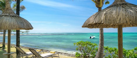 Na praia, espreguiçadeiras, prática de mergulho livre no local