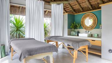 Relax in a serene spa room with two massage tables, a large mirror, and a peaceful ambiance.