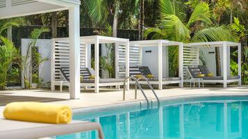 A poolside area with lounge chairs and a pool.