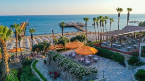 A coastal resort with a pier extending into the sea, outdoor seating areas, and palm trees. - Arum Barut Collection - Ultra All Inclusive (Manavgat)