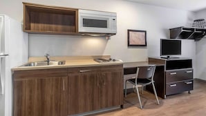 A compact kitchen with a microwave, sink, and wooden cabinets. - Extended Stay America Select Suites - Beaumont (Beaumont)