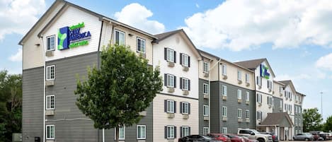 A multi-story hotel with a sign for Extended Stay America Select Suites.