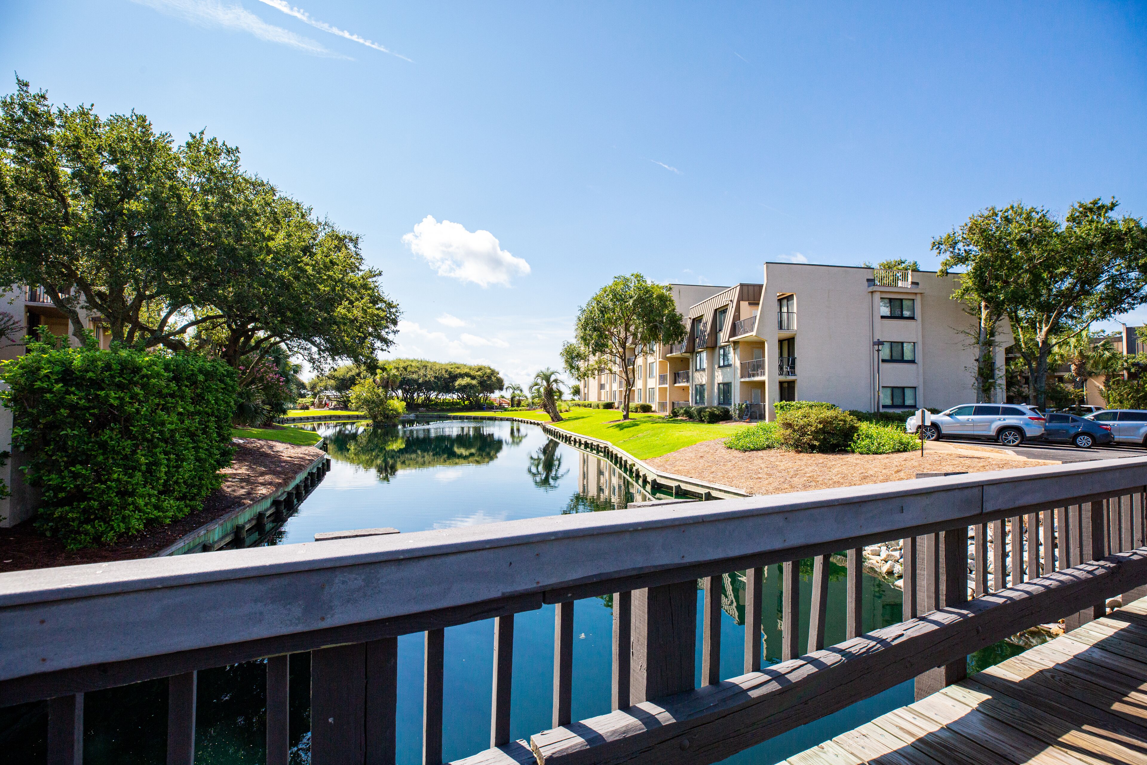 A residential area with a canal, wooden deck, and modern apartment buildings.
