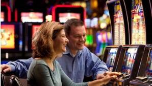 A couple at a slot machine in a casino.