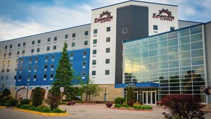 A hotel with a modern design, featuring a large glass entrance and a blue and white facade.