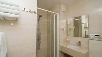 Une salle de bain moderne avec une douche à parois de verre, un lavabo avec un miroir et un porte-serviettes.
