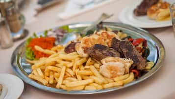 A plate of food with fries, meat, and vegetables.