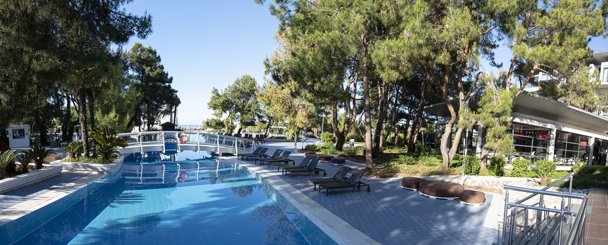 A swimming pool with lounge chairs and a boat-shaped deck.