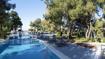 A swimming pool with lounge chairs and a boat-shaped deck.