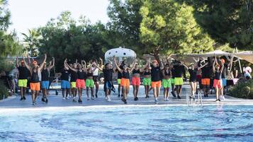 Un grupo de personas realizando una rutina de ejercicios sincronizados junto a una piscina.