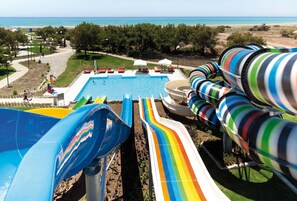Zona de piscina con toboganes y vista al mar.
