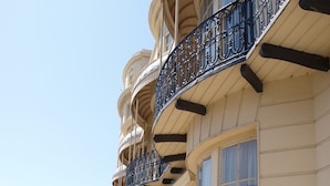 A row of buildings with balconies, a sidewalk, and parked cars. - The Beach Hotel (Brighton)