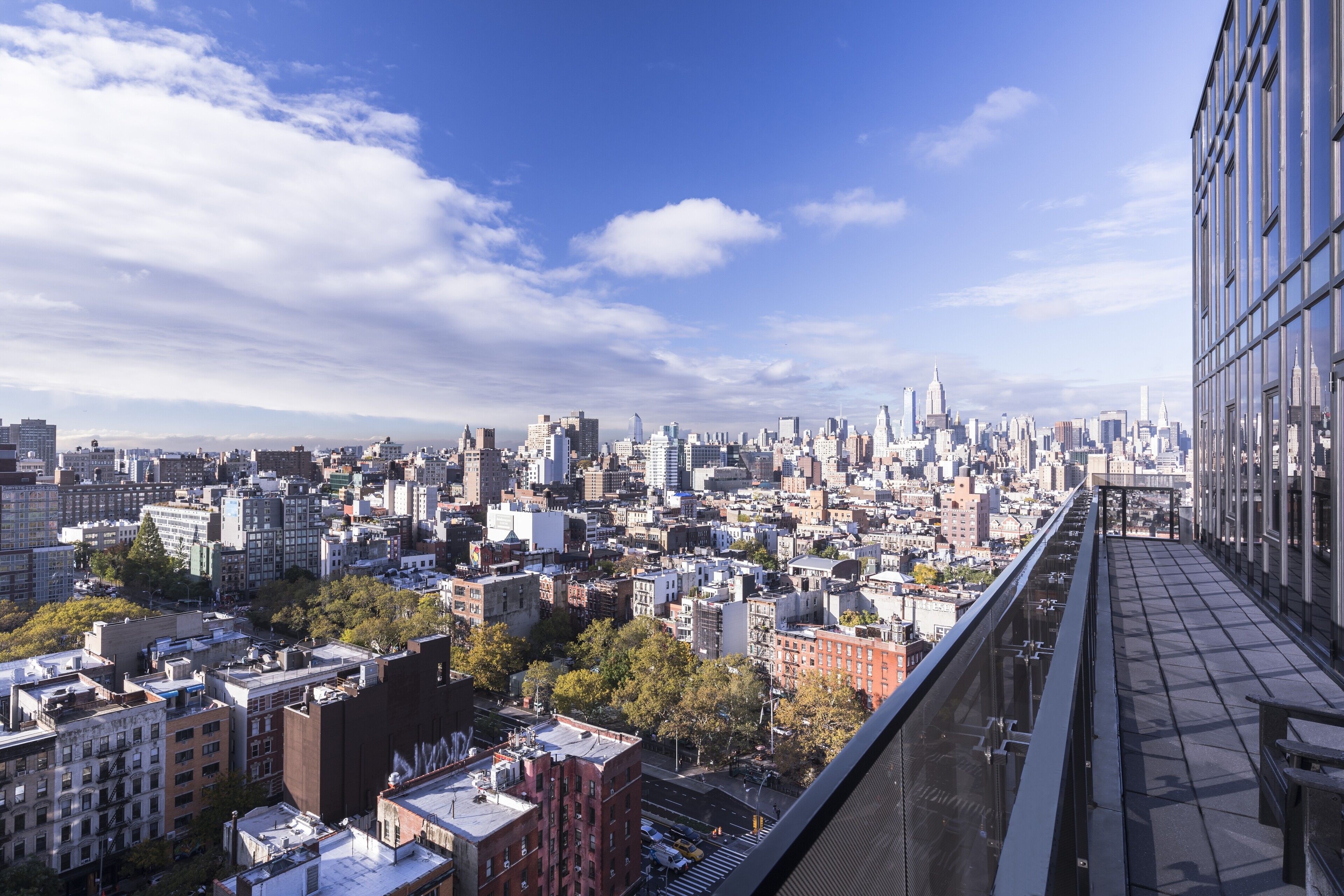 Un immeuble de grande hauteur offrant une vue panoramique sur la ville, avec différents bâtiments et un ciel dégagé.