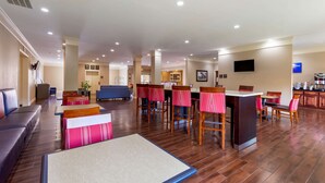 A hotel lobby with a seating area, a bar, and a dining section. - Comfort Inn Huntsville Research Park (Huntsville)