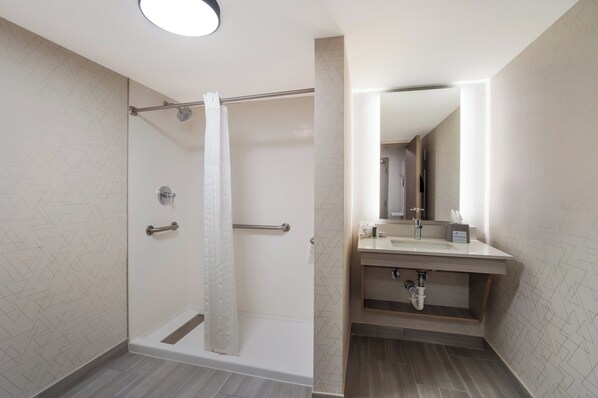 A modern bathroom with a glass-enclosed shower, a vanity with a mirror, and a sink. - Comfort Suites Lexington (Lexington)
