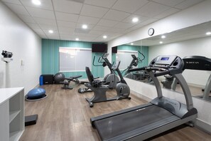 Een sportschool met loopbanden, elliptische trainers en fitnessballen.