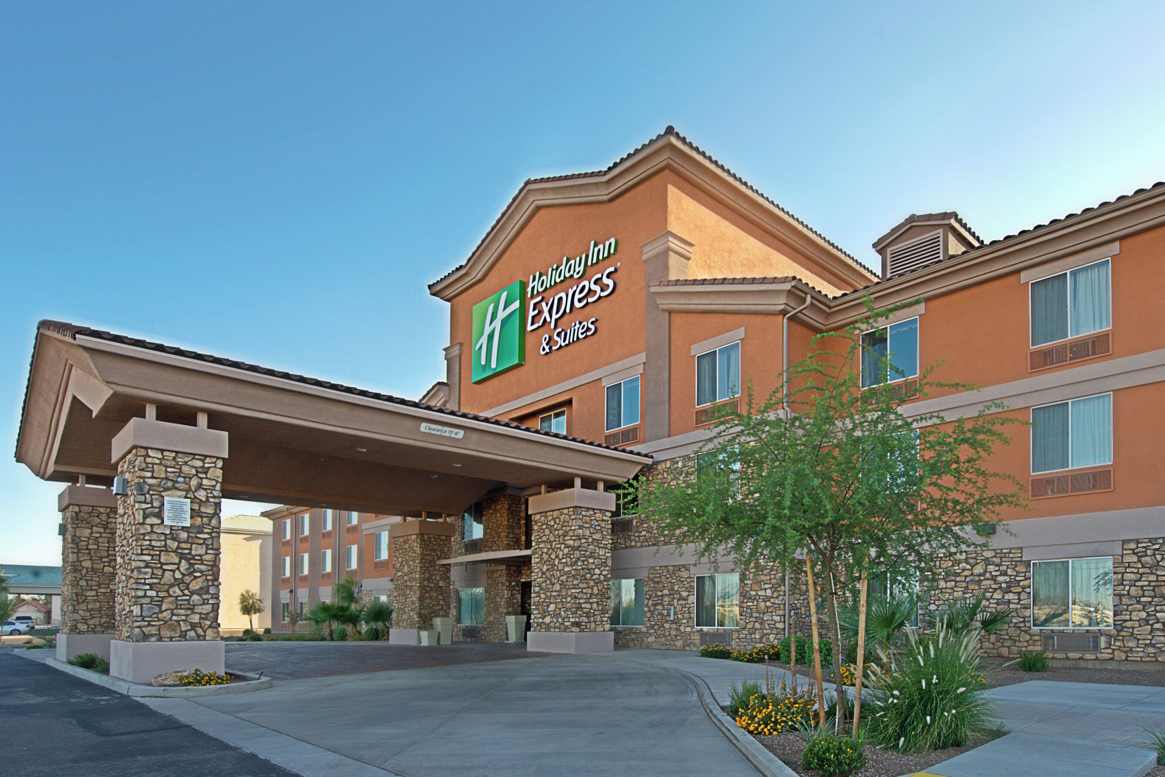 Un hôtel Holiday Inn Express doté d’une façade en pierre, de nombreuses fenêtres et d’une entrée abritée.
