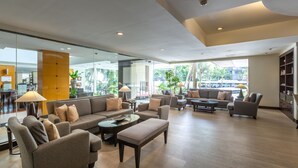 Un hall amplio con varias zonas de estar, ventanas grandes que ofrecen vistas al exterior y un diseño interior moderno.