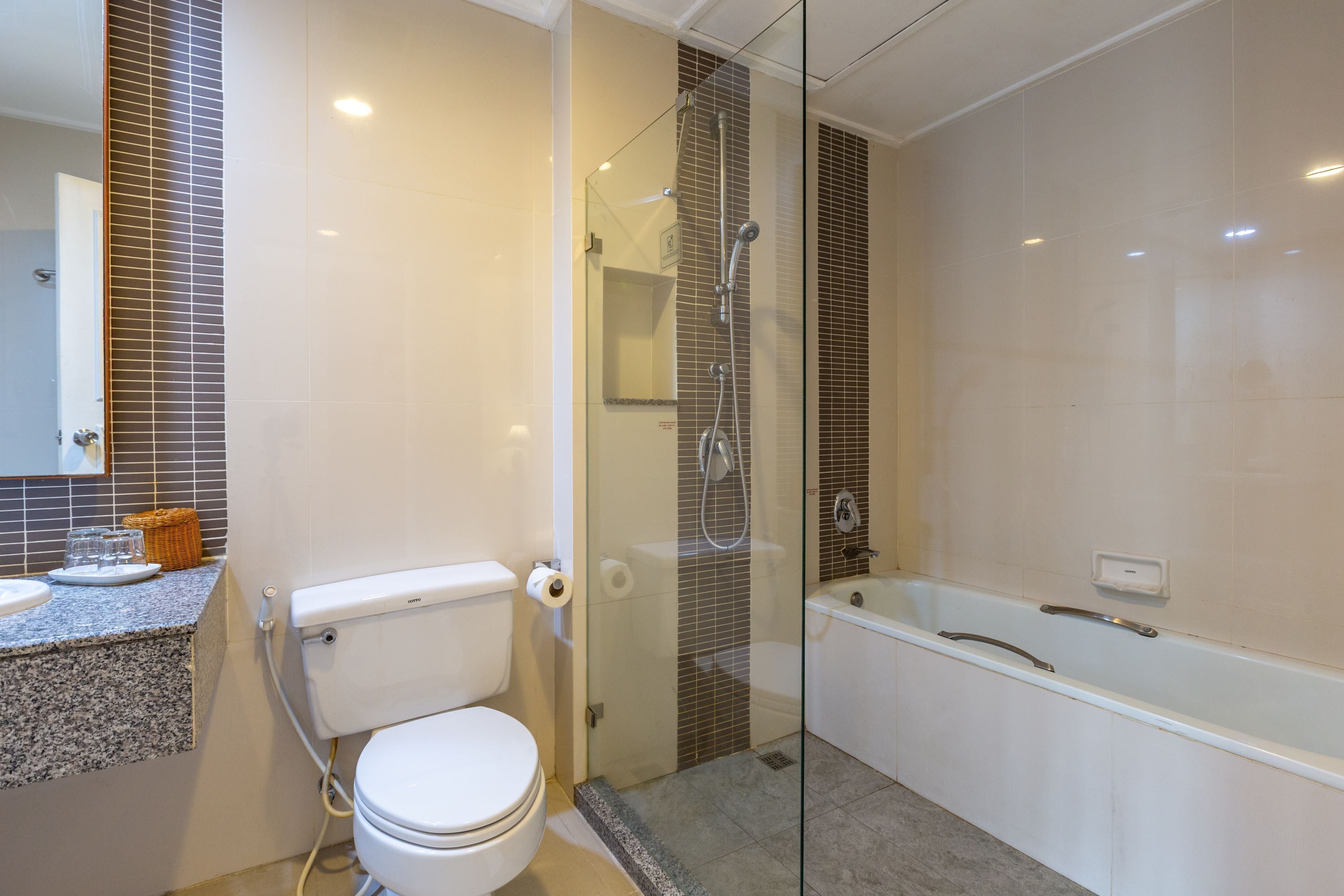 A modern bathroom with a toilet, sink, and glass-enclosed shower area.