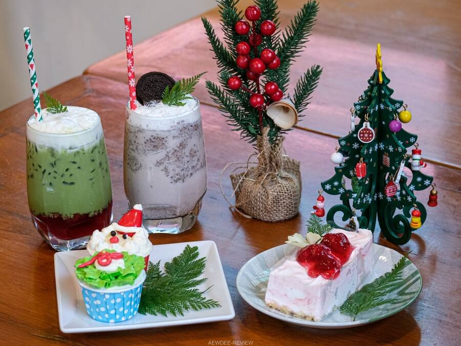 Une table avec deux boissons, un petit sapin de Noël et un cupcake.