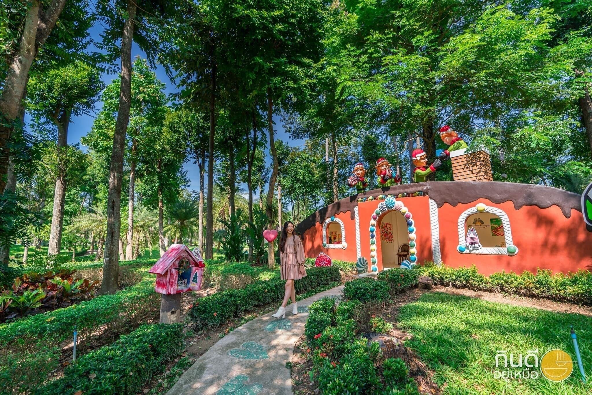 A whimsical treehouse with a red exterior and a thatched roof, surrounded by lush greenery and trees.