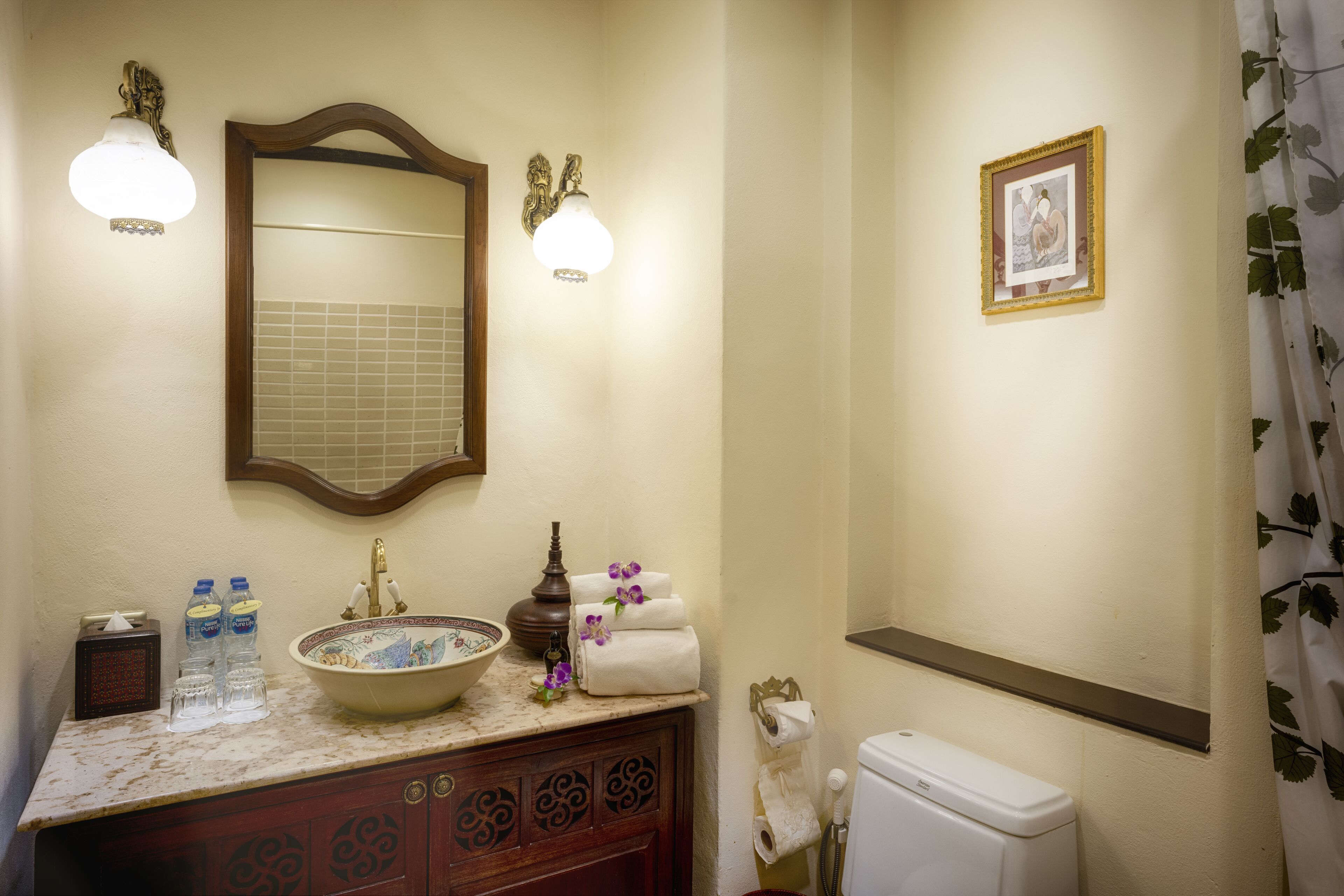 Een badkamer met een wastafel, spiegel, handdoekrek, toilet en douchegordijn.