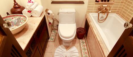 A bathroom with a toilet, sink, and bathtub.