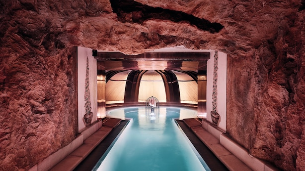 Una piscina interior rodeada por un muro de piedra.
