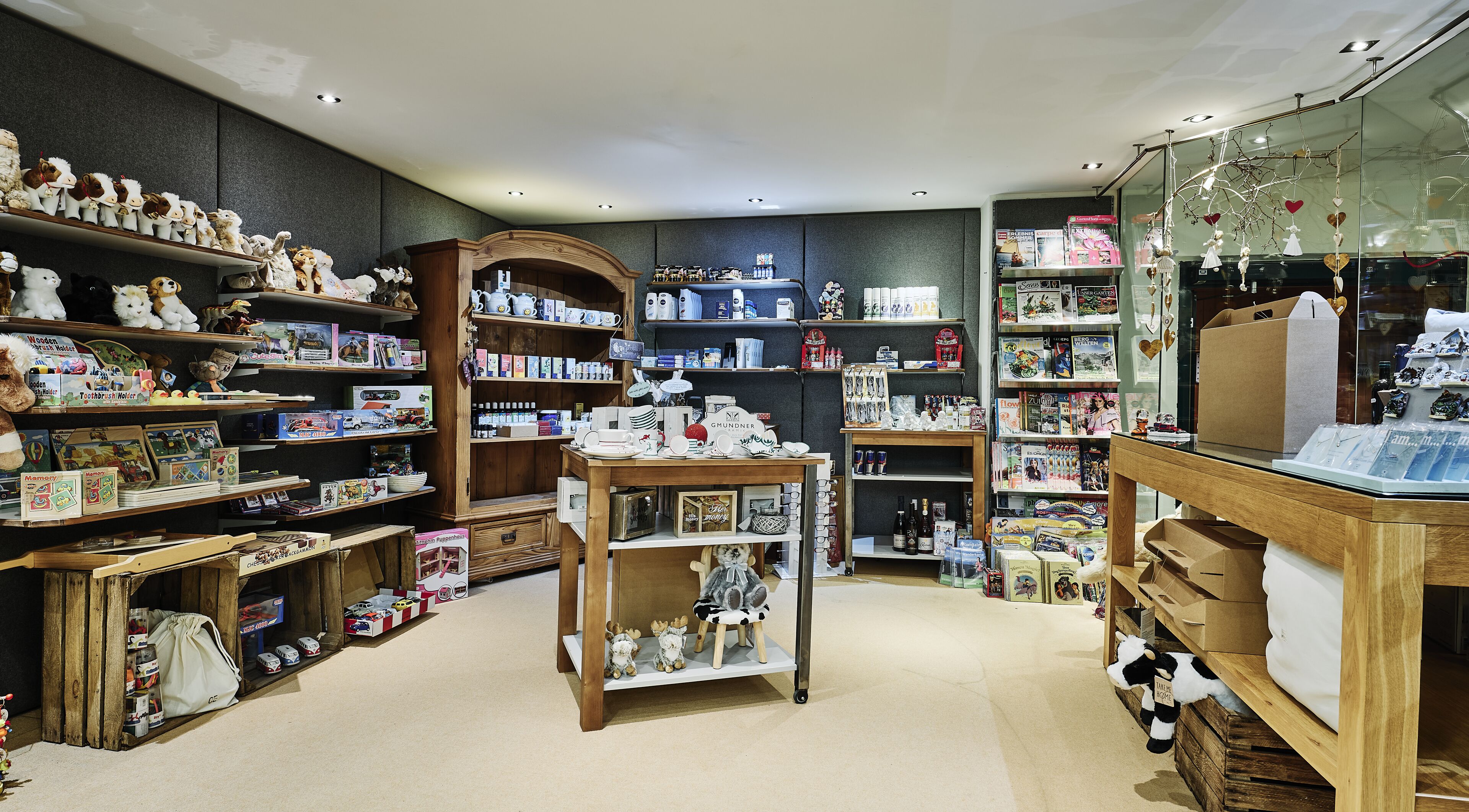 A store with wooden shelves filled with toys, books, and household items.