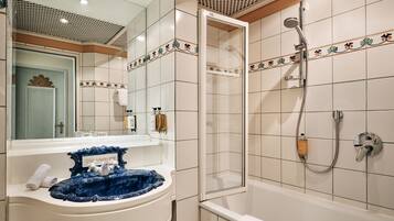 Une salle de bain équipée d’un lavabo, d’un miroir, d’une douche et d’une baignoire.