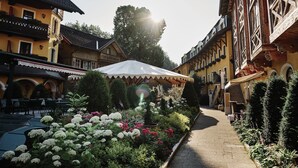 Un patio con un sendero, rodeado de edificios tradicionales con balcones y macetas de flores.