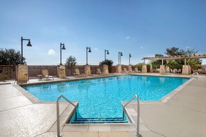 A swimming pool with steps leading into it, surrounded by lounge chairs and a pergola. - Embassy Suites by Hilton San Marcos Hotel Conference Center (San Marcos)
