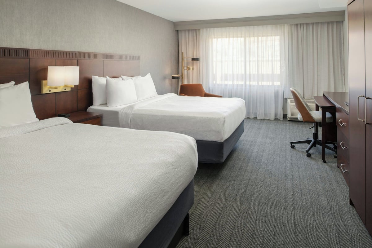 Premium bedding, desk, laptop workspace, blackout drapes