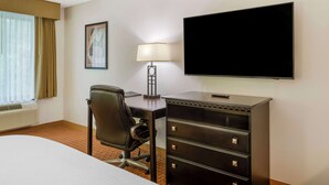 A hotel room with a bed, a desk with drawers, a chair, a TV, a lamp, and a window with curtains. - Best Western Plus Hopewell Fort Lee (Hopewell)