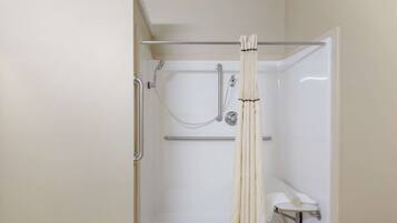 Un espace douche doté d’une porte en verre, d’un porte-serviettes et d’un pommeau de douche.