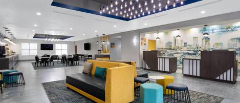 Un moderno vestíbulo de hotel con sofá, zona de estar y mostrador de recepción.