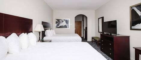 A hotel room with two beds, a TV, a dresser, and a painting on the wall.