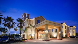 A hotel with a modern design, featuring a covered entrance and multiple floors.