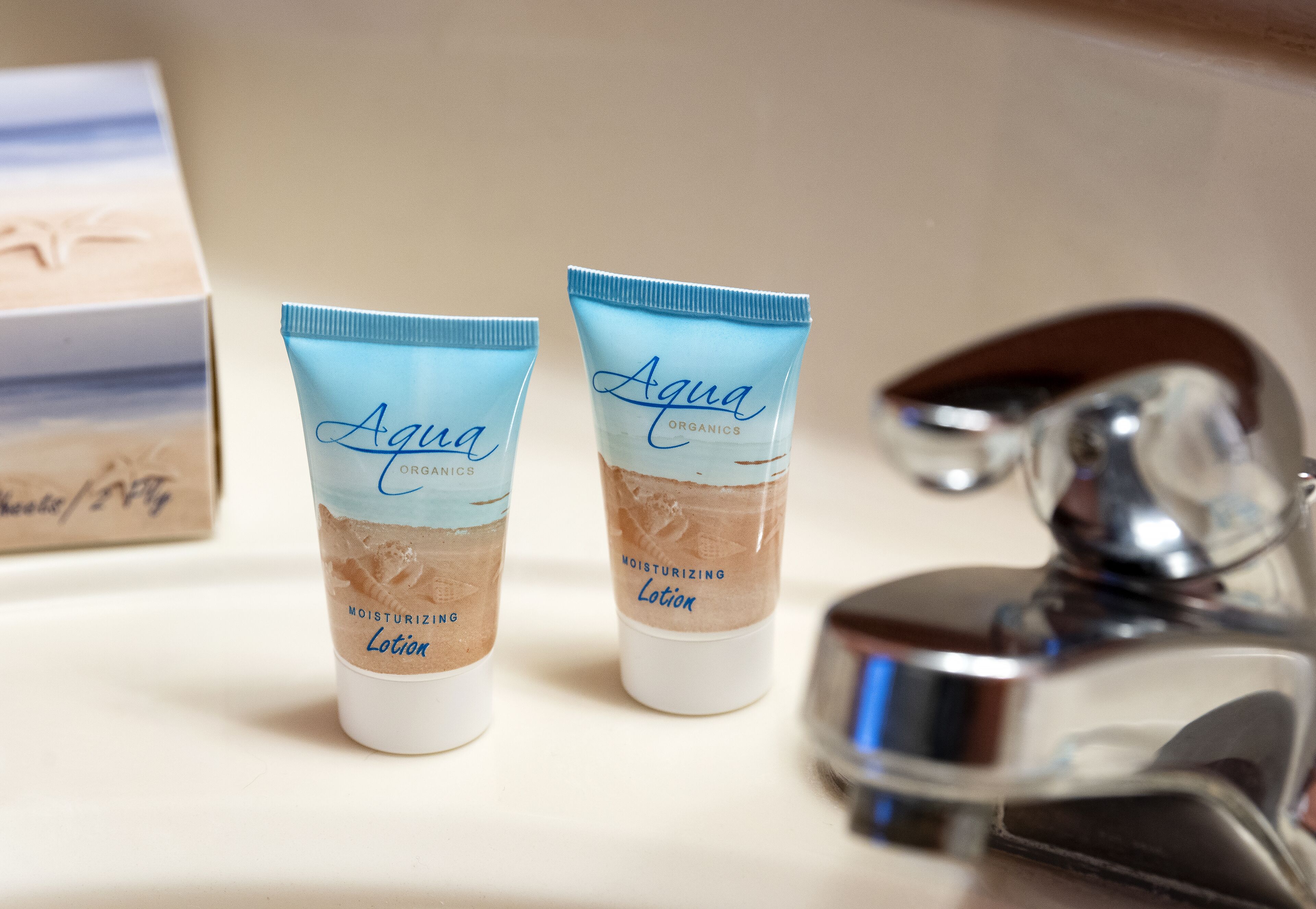 Dos tubos de Loción Hidratante Aqua Organics sobre una encimera de baño.